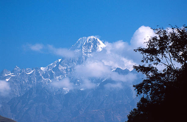 An image portraying the stunning Ganesh Himal, its snow-dusted peaks gleaming under the sunlight, exemplifying the imposing magnificence of the Himalayan range.
