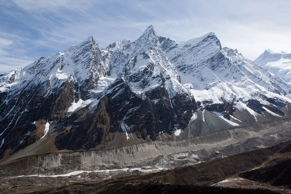 A breathtaking picture of Mount Manaslu, the eighth-highest mountain in the world, with a clear blue sky in the background and a snow-covered top drenched in sunlight.