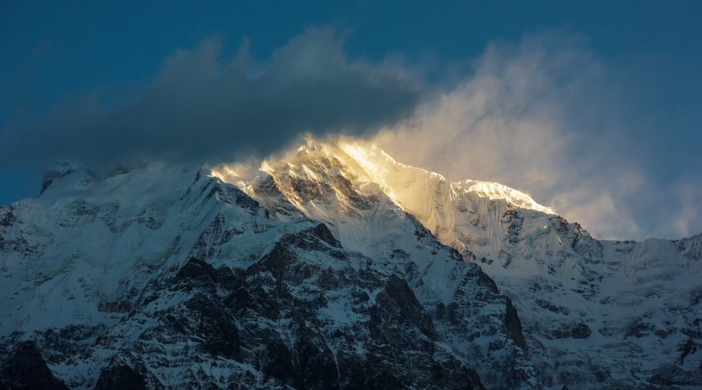 A captivating sunrise over the Annapurna Base Camp (ABC) illuminates the surrounding peaks and landscape with warm hues, casting a magical glow over the majestic mountains.