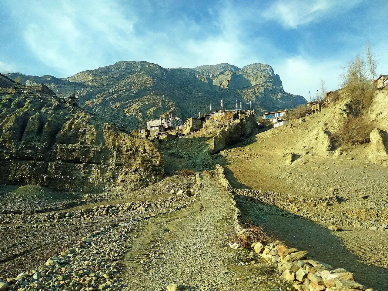 Scenic view of Manang Valley with snow-capped peaks, green meadows, and traditional villages along the Annapurna Circuit Trek.