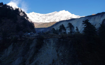 Stunning view of the Dhaulagiri mountain range with snow-capped peaks, seen from a trekking trail on the way to Khopra, surrounded by green hills and clear skies.