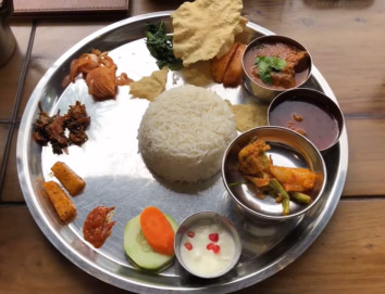 Traditional Nepali Dal Bhat set meal found during Annapurna Circuit Trek, served with rice, lentil soup, vegetables, and pickles.