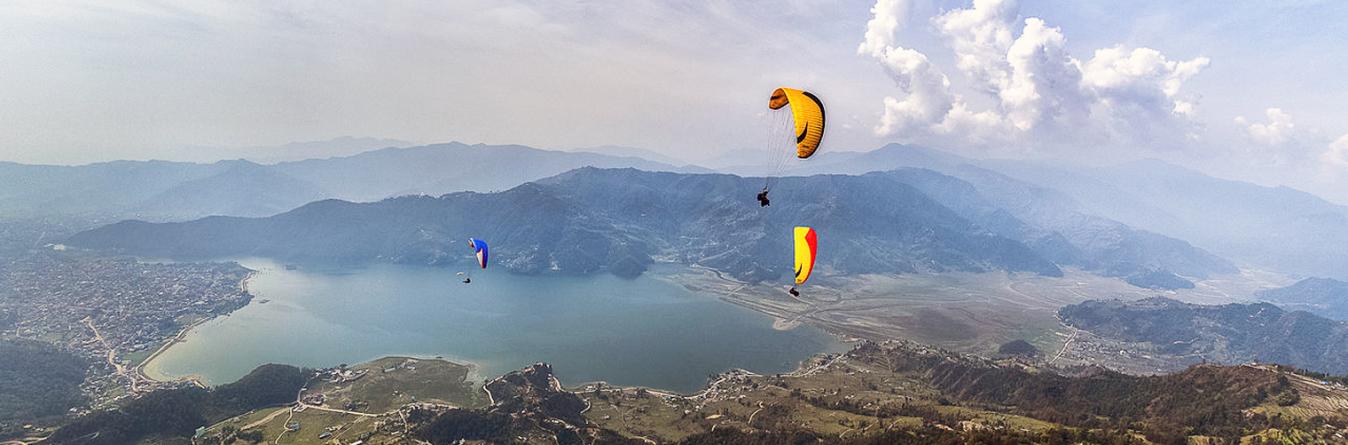 Paragliding adventure above Pokhara city with Himalayas backdrop